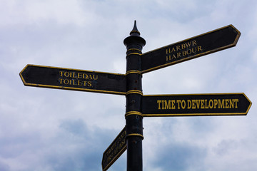 Word writing text Time To Development. Business photo showcasing a length of time during which a company grows or develop Road sign on the crossroads with blue cloudy sky in the background