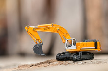 Yellow Excavator Model Toy Performs Excavation Work On A Construction Site. (Image Stacking Technique)