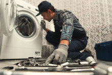 Choosing The Right Tool. Plumber Repairing Washing Machine