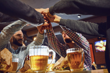 Beer friends free time concept. Cheerful friends with glasses and beer in the bar.