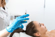 © Kate - The beautician holds a syringe with an rejuvenation injection on the background of the patient. A young girl is undergoing a course of spa treatments in the office of a beautician. Moisturizing