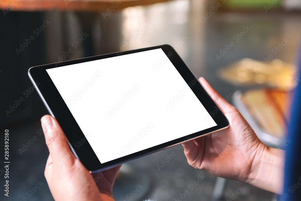 Mockup image of a woman holding black tablet pc with blank white desktop screen - obrazy, fototapety, plakaty 