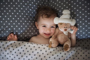 A little girl goes to bed with her favorite toy bear. Happy healthy childhood. Say no to insomnia.