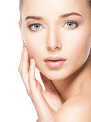 Wall Mural - Young woman with healthy clean skin touches the face. Skin care concept.