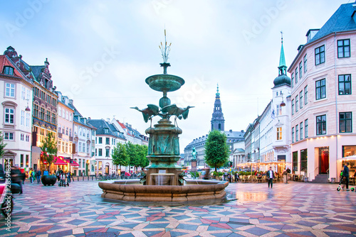 Leinwand Poster  Stork Fountain on the Amagertorv (Amager Square) and the longest pedestrian street in the world Stroget in Copenhagen Copenhagen, Denmark