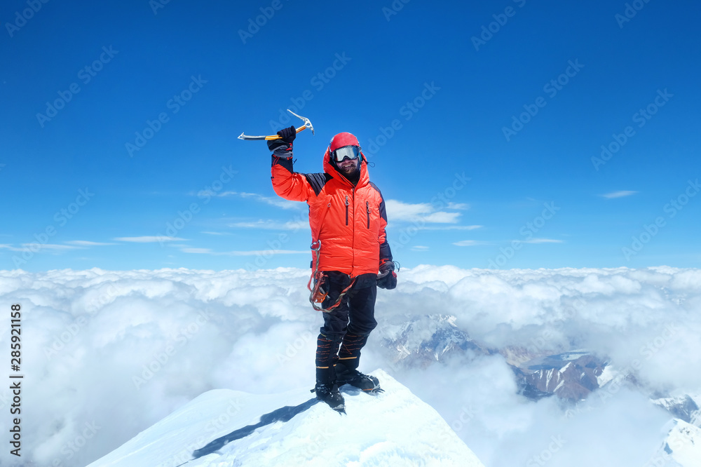 Happy man climber in bright red down jacket reaches the summit of mount Everest, Nepal. - obrazy, fototapety, plakaty 