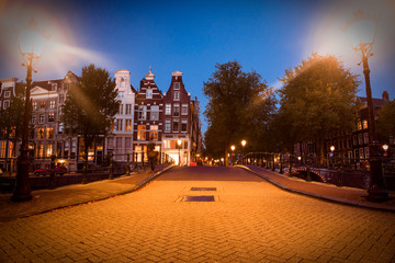 Fototapete - Street scene in Amsterdam at night with lights and architecture