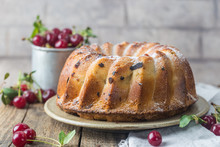 Fresh Homemade Bundt Cake With Cherry On Wooden Table