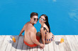 © New Africa - Woman in bikini with boyfriend near outdoor pool. Happy young couple
