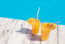 Refreshing Cocktails Near Outdoor Swimming Pool On Sunny Day. Space For Text