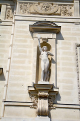 Architectural details and statues on the wall of the Palais de Justice in Paris