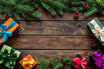 Frame from gifts in boxes and spruce for new year eve on wooden background top veiw mockup