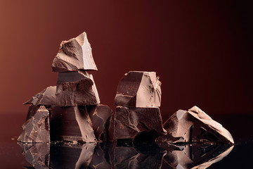 Pieces of dark chocolate on a dark background.