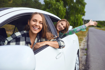 A group of happy friends are driving in a car.