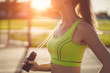 Healthy sportswoman in sportswear doing cardio exercises with jump rope outdoors. Keep fit and having sports lifestyle