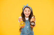 Bakery And Confectionery Concept. Kid Girl Hold Glazed Muffins. Delicious Cupcakes. Happy Childhood. Adorable Smiling Child With Cupcakes On Yellow Background. Cafe Restaurant Food. Yummy Cupcakes