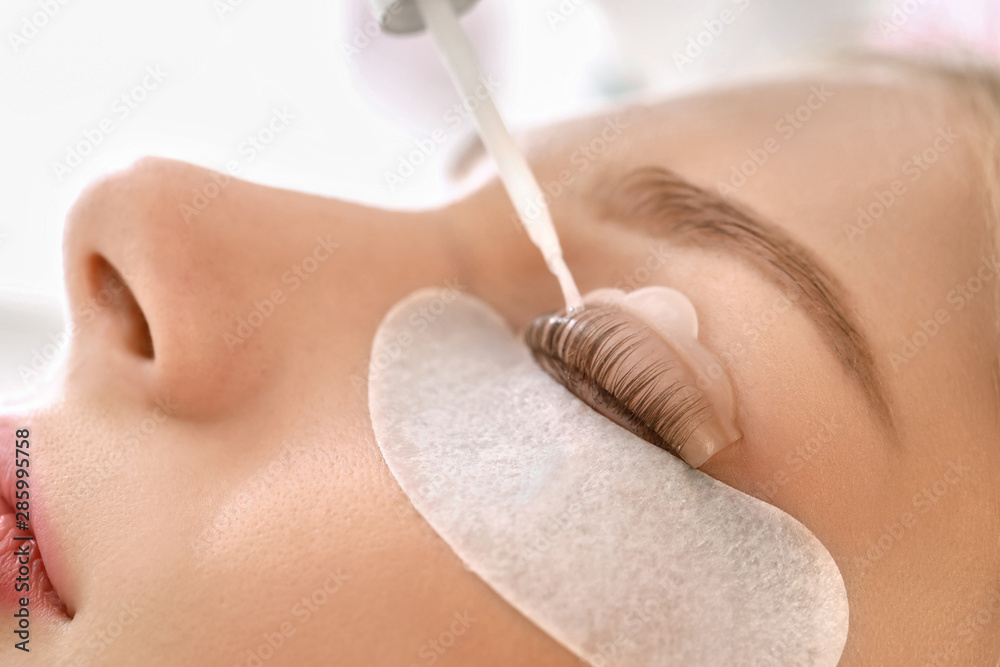 Young woman undergoing procedure of eyelashes lamination in beauty salon, closeup - obrazy, fototapety, plakaty 