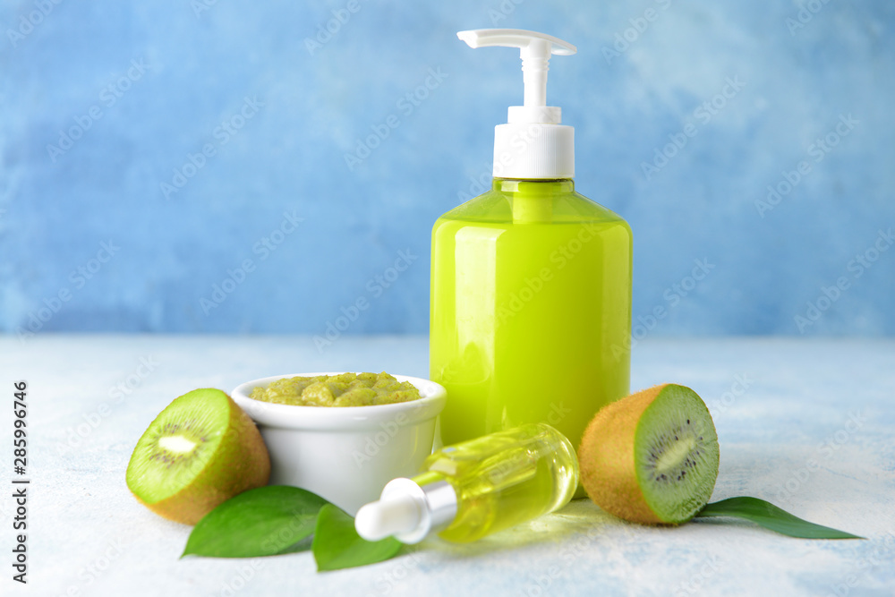 Cosmetics with kiwi on color background