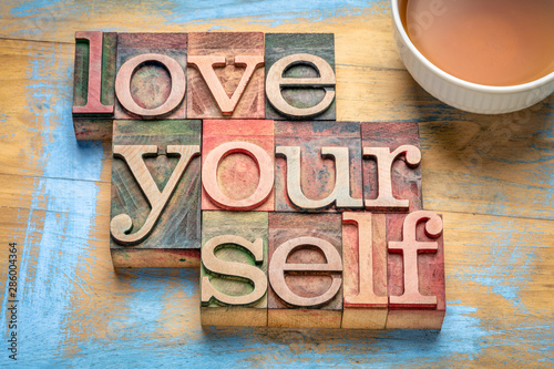 Fotografía love yourself word abstract in wood type, self respect concept