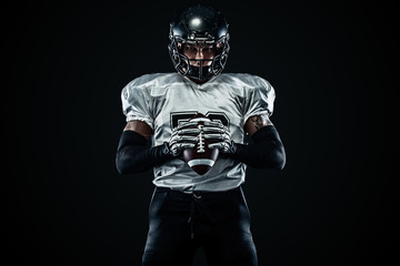 Wall Mural - American football sportsman player in helmet on black background. Sport and motivation. Team sports.