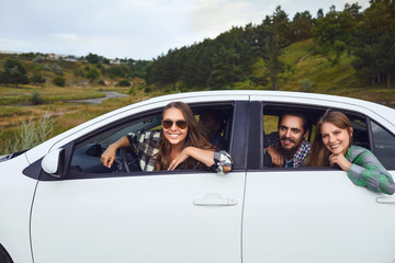 Wall Mural - A group of happy friends are driving in a car.