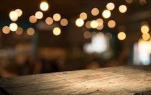 Empty Wood Table Top On Blur Light Gold Bokeh Of Cafe Restaurant In Dark Background