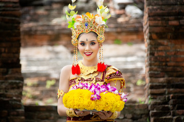 Portrait of an Balinese dancer is holding oblation after prayer in Traditional Attire at Bali Gate