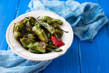 Wall Mural - grilled green pepper on white plate on wooden background