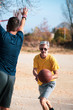 © creativefamily - Father and son playing basketball in the park