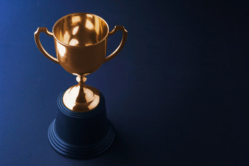 gold trophy on black background.