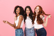 © Drobot Dean - Cheery smiling positive young three multiethnic girls friends posing isolated over pink wall background.