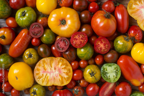 Fotografía Close up of colorful tomatoes, some sliced, shot from above