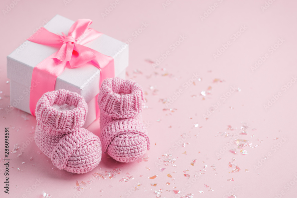 Obraz Pair of small baby socks and gift box on pink background with copy space for your warm message, baby shower, first newborn party background, copy space fototapeta, plakat