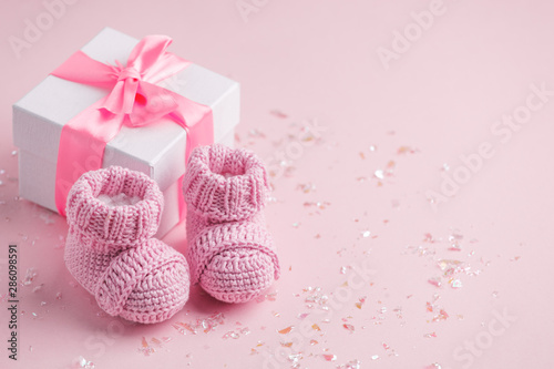 Fotomural Pair of small baby socks and gift box on pink background with copy space for you