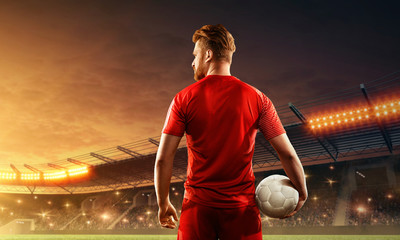 Wall Mural - Professional soccer player in sports uniform with a ball in his hands