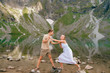 Expressive couple having fun in black lake (Czarny Staw) under Mount Rysy in High Tatra national park.