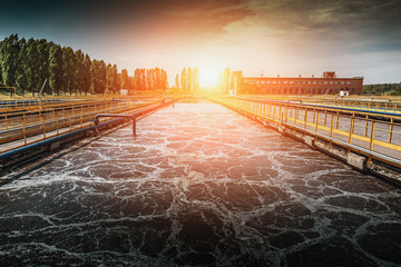 Wastewater treatment plant at sunset. Tanks for aeration and cleaning of sewage mass