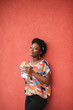 Lifestyle portrait of dark skinned smiling girl eating fast food over red brown wall on background.