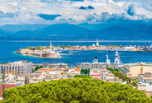 Beautiful panorama of Messina port with blue mountains in the background. It is written on the seawall in Latin \
