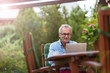 © pikselstock - Senior man working on laptop in the garden