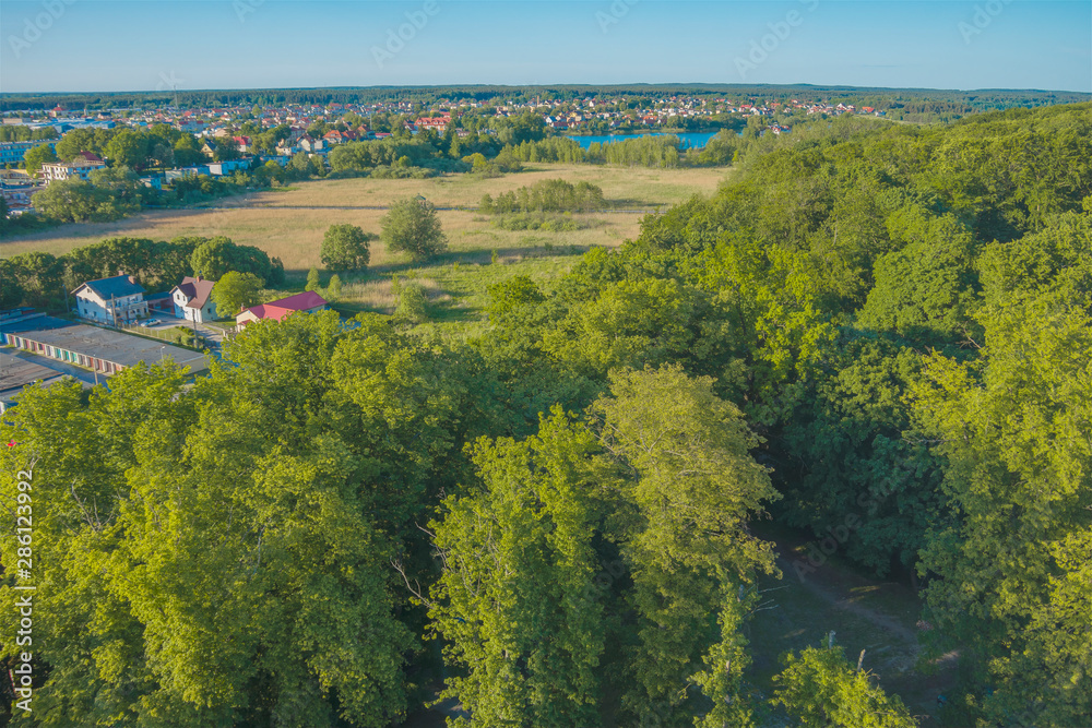 Obraz na płótnie widok z góry lot ptaka park panorama miasta zieleń lato pola budynki domy w salonie
