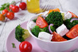 © kcuxen - Light salad with broccoli, cherry tomatoes and feta cheese in a white ceramic bowl