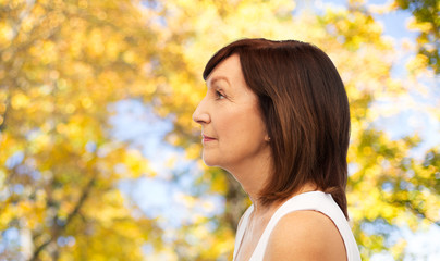 Sticker - beauty, rhinoplasty and old people concept - profile of senior woman over natural autumn background