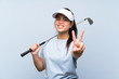 Young golfer Asian girl over isolated blue background smiling and showing victory sign