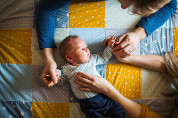 Wall Mural - A top view of a newborn baby lying on bed at home.