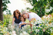 © Halfpoint - Senior grandparents and granddaughter gardening in the backyard garden.