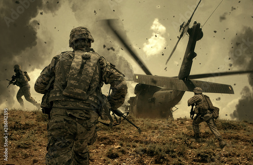 Photographie Military helicopter and forces between fire and dust in the battlefield