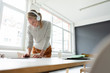 © Westend61 - Young businesswoman listening to music with headphones in office