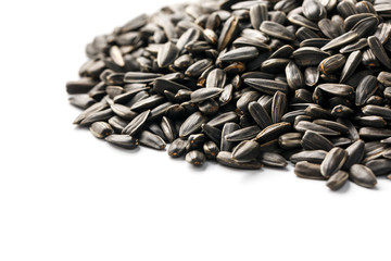 Seeds in a black shell are a bunch on a white background. In full screen