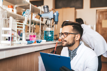 two middle age scientists and researchers work in chemical laboratory.